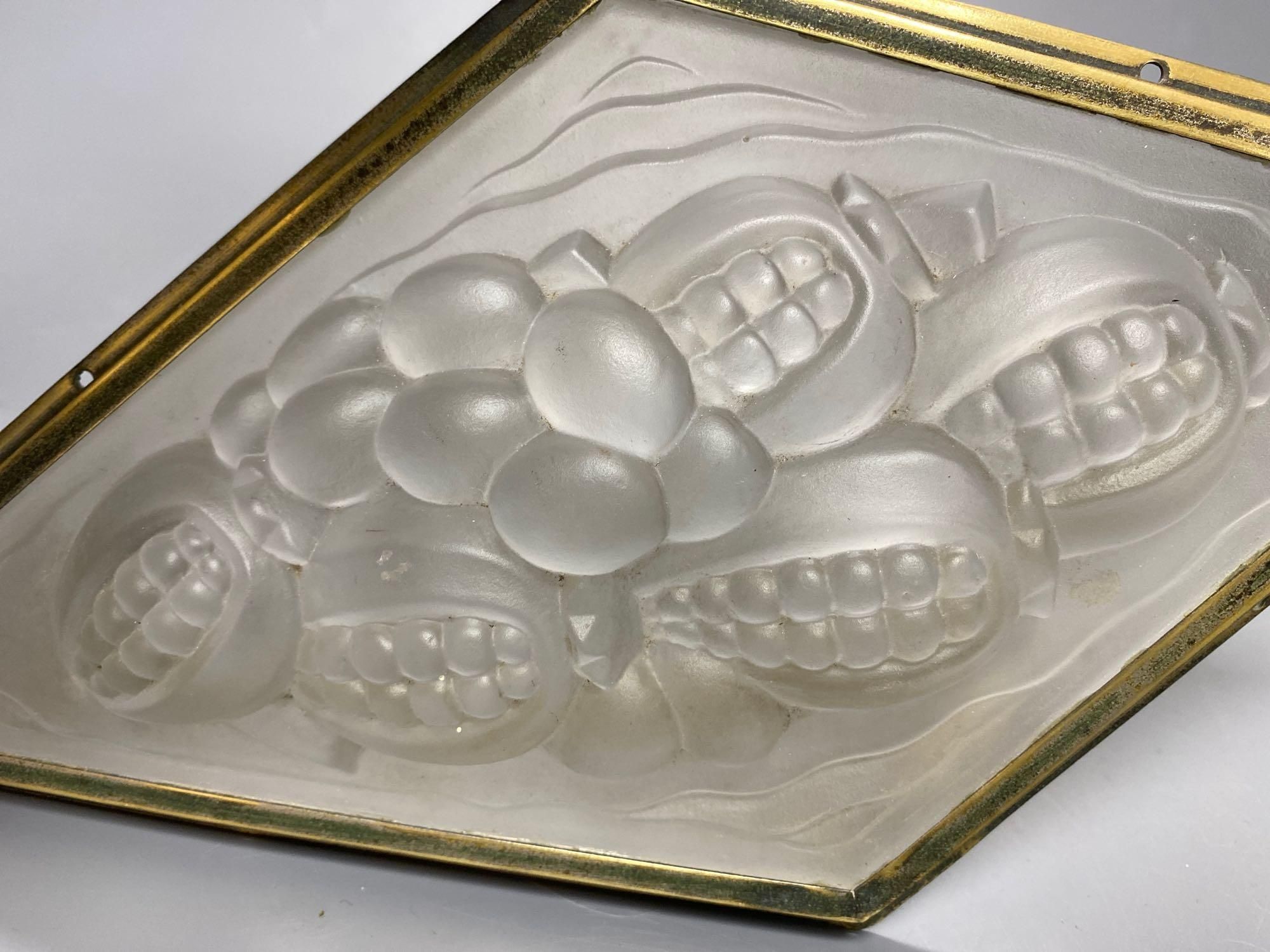 A pressed, frosted glass lozenge shape panel, within brass frame, height 35cm